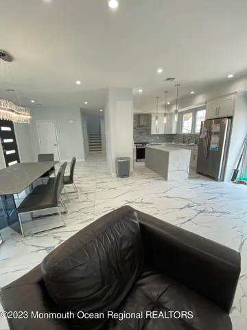 a kitchen with stainless steel appliances kitchen island granite countertop a sink and white cabinets
