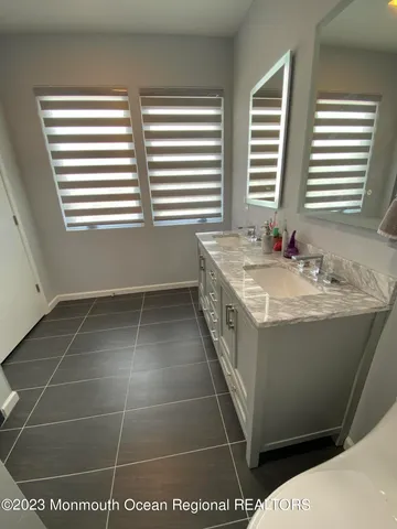 a bathroom with a tub a sink and a window