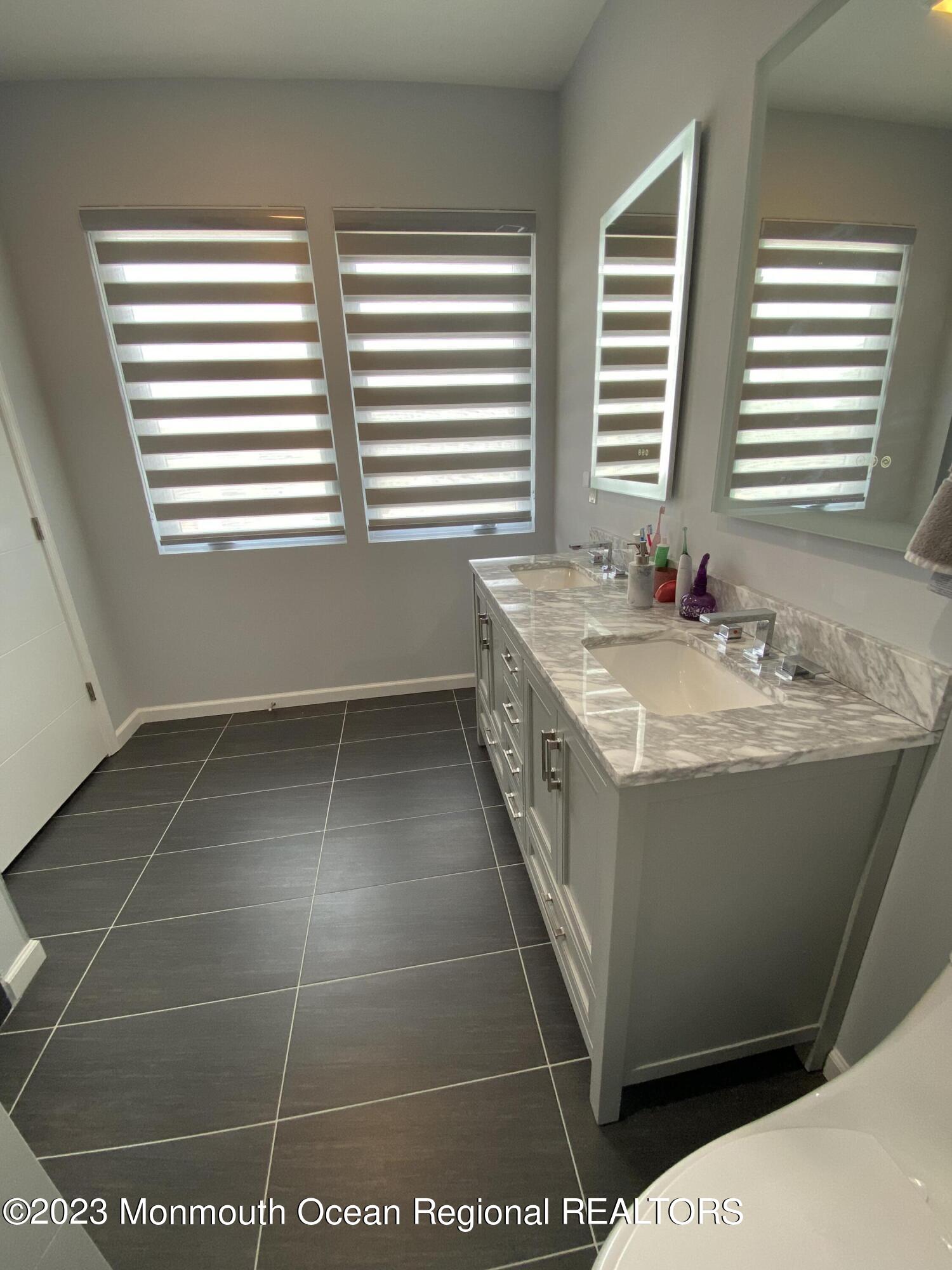 975 Van Ct Avenue Long Branch, NJ 07740 - Photo 10 of 16 a bathroom with a tub a sink and a window