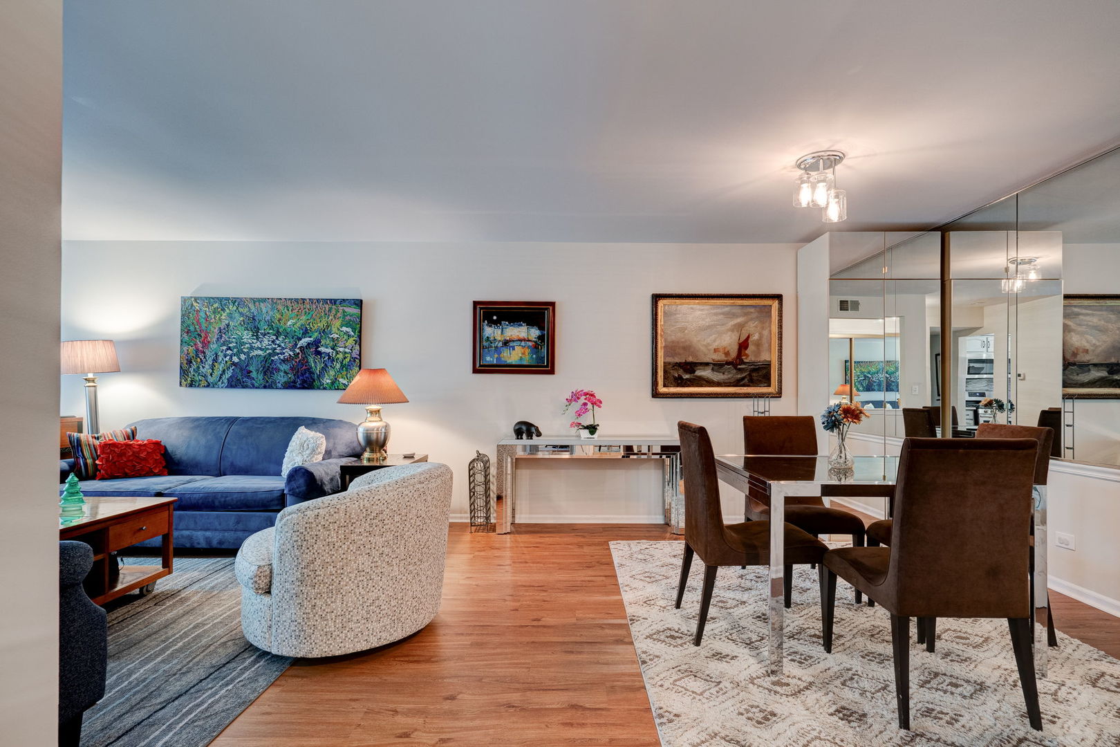 1-s150 Spring Road, Unit 2B Oak Brook, IL 60181 - Photo 2 of 10 a living room with couches and a flat screen tv with kitchen view