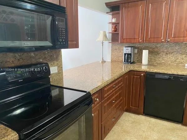 a kitchen with granite countertop a stove and a microwave