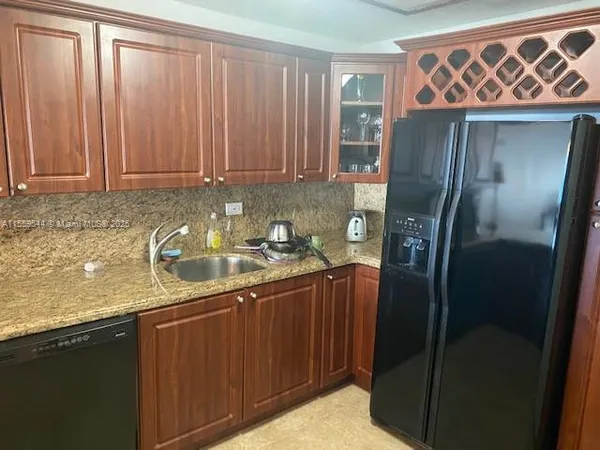 a kitchen with stainless steel appliances granite countertop a refrigerator a sink and dishwasher