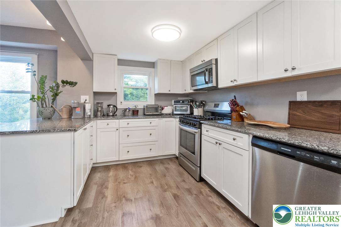 506 Richmond Road Bangor, PA 18013 - Photo 11 of 43 Polished quartz countertops complement timeless white shaker cabinetry and durable wood-look flooring.