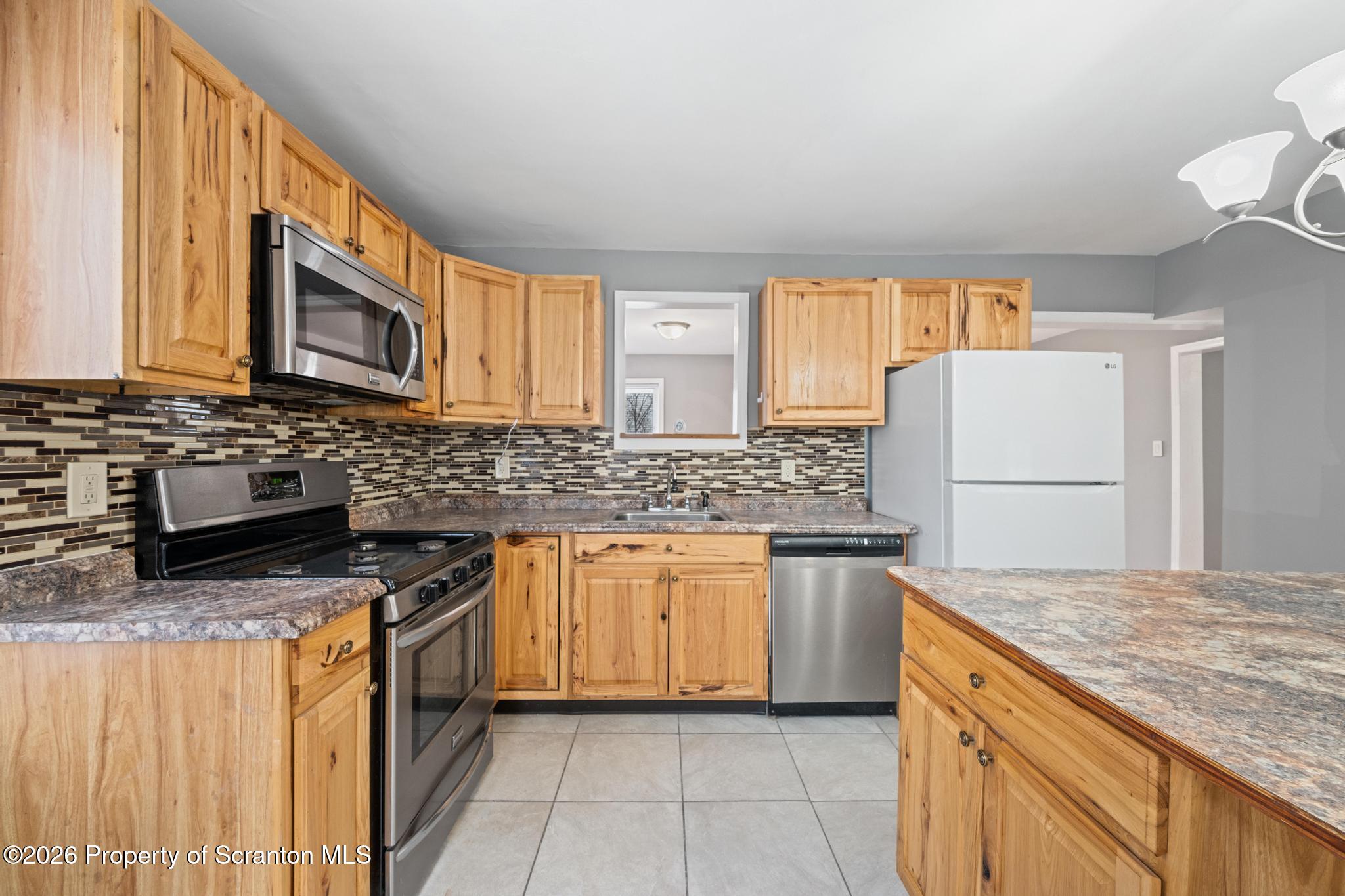 2717 North Main Avenue Scranton, PA 18508 - Photo 16 of 36 a kitchen with stainless steel appliances granite countertop a stove a sink dishwasher and a refrigerator
