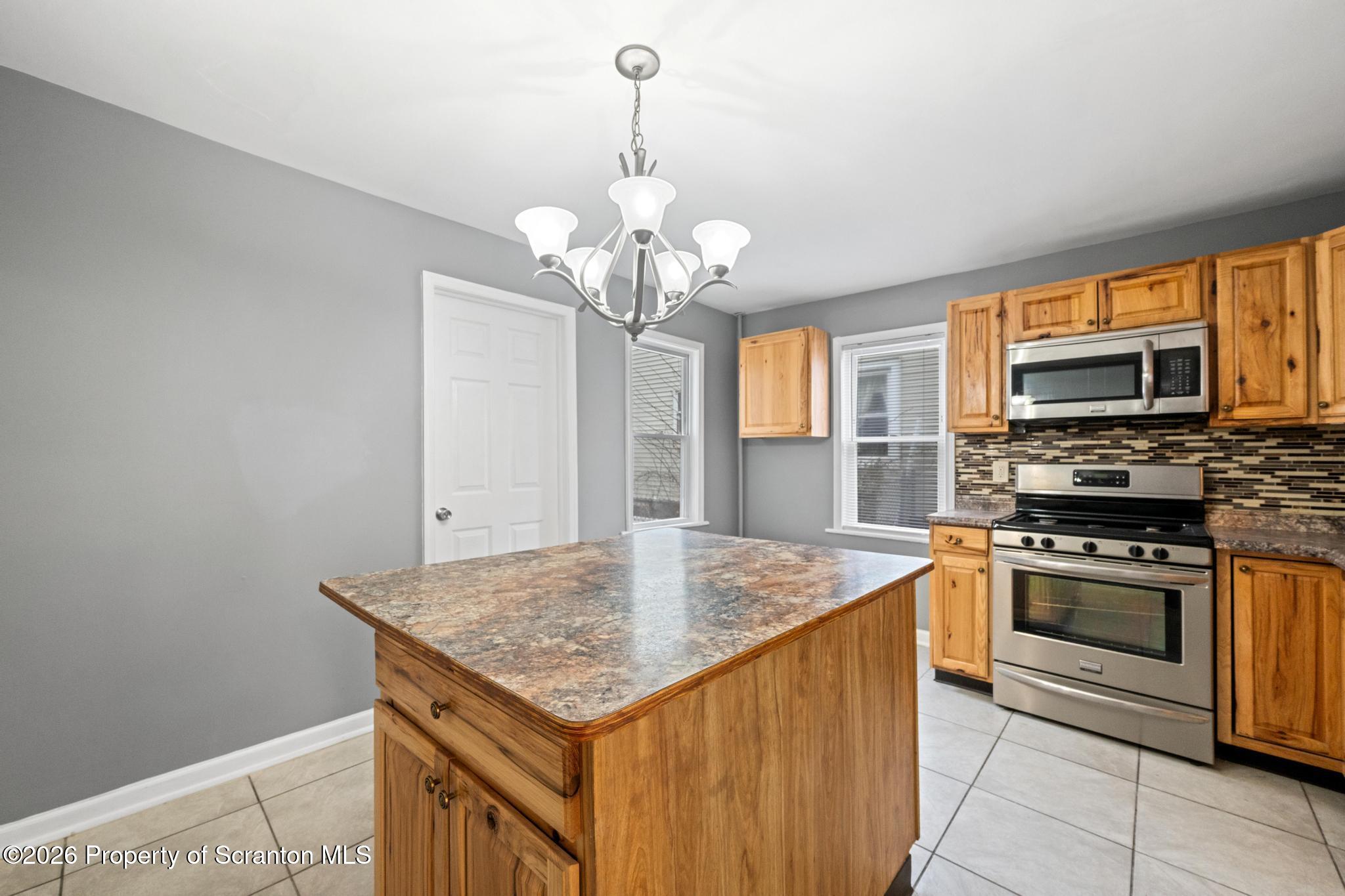 2717 North Main Avenue Scranton, PA 18508 - Photo 18 of 36 a kitchen with stainless steel appliances granite countertop a sink and dishwasher a stove top oven with wooden floor