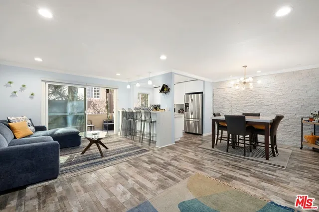 a living room with furniture a dining table and chairs with kitchen view