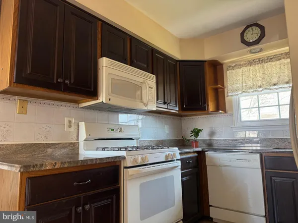 a kitchen with stainless steel appliances granite countertop a sink stove and microwave