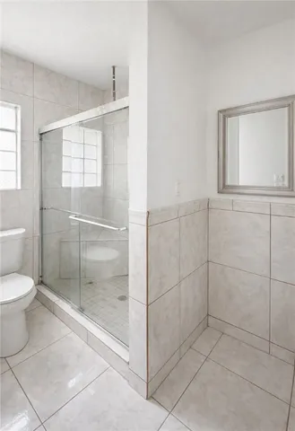 a bathroom with a toilet and a shower