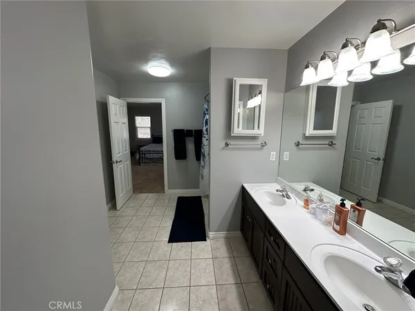 a spacious bathroom with a double vanity sink a mirror and a shower