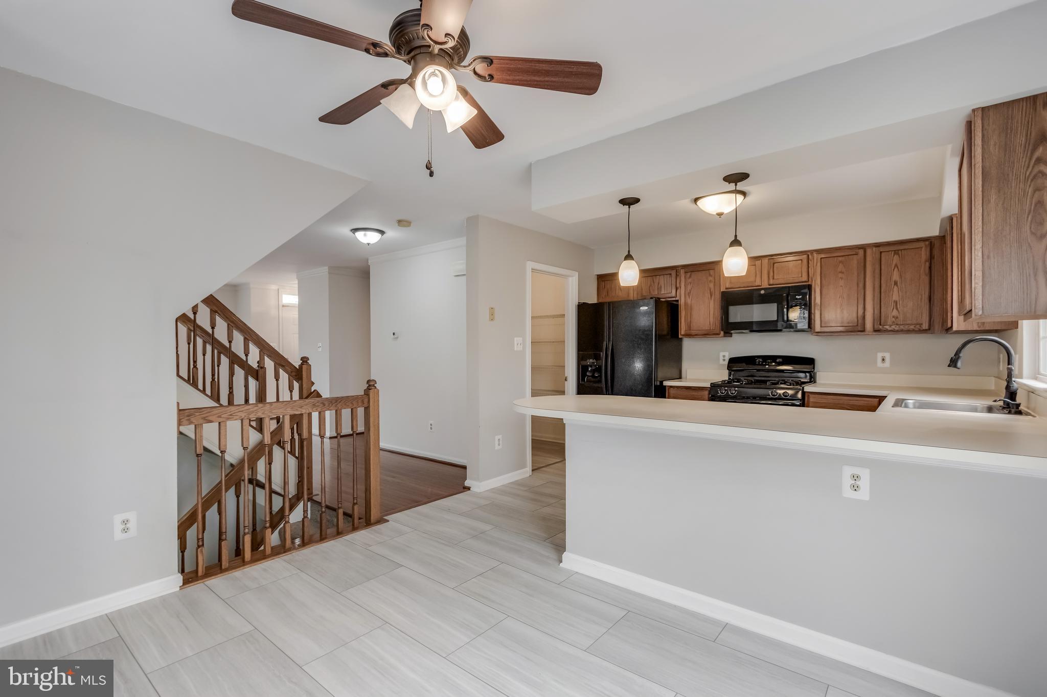 45550 Whitcomb Square Sterling, VA 20166 - Photo 6 of 24 a kitchen with stainless steel appliances kitchen island granite countertop a refrigerator a stove a microwave oven a sink with island and chairs