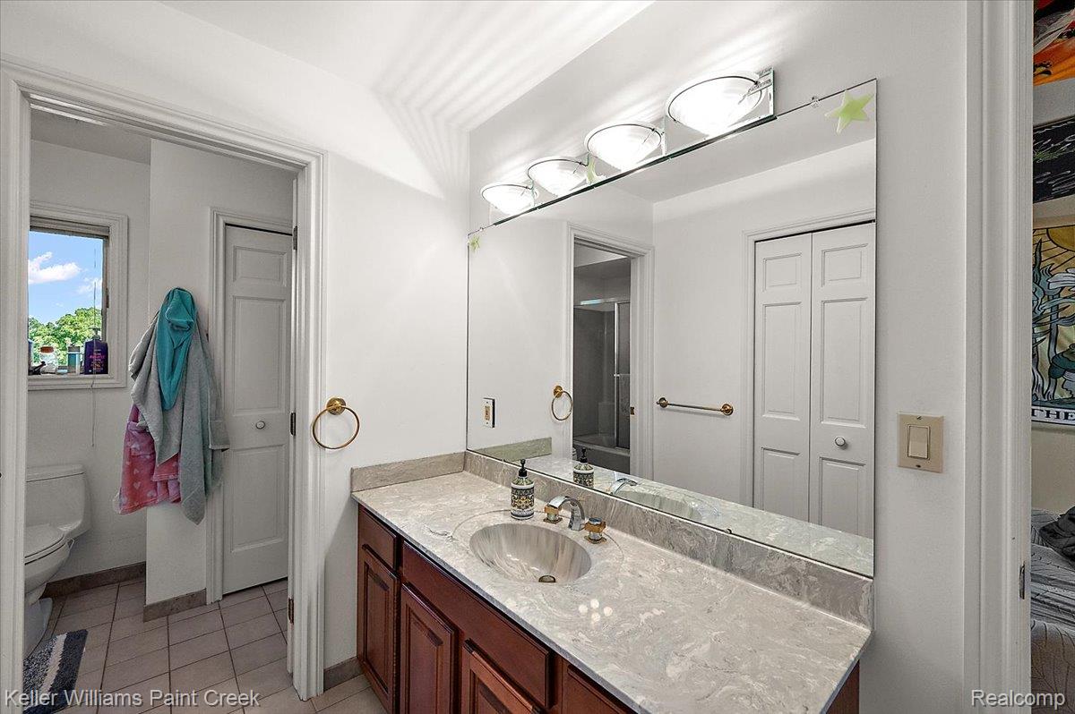 69069 Campground Road Romeo, MI 48065 - Photo 60 of 78 Bathroom vanity featuring a light-colored countertop with an undermount sink and a polished brass faucet
