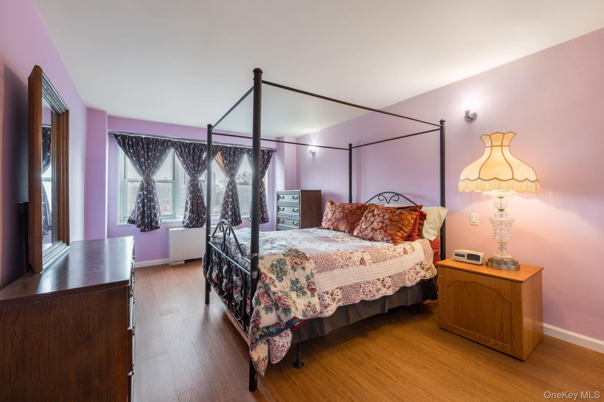 85-15 Main Street, Unit 3E Queens, NY 11435 - Photo 11 of 16 a bedroom with a bed and a chandelier