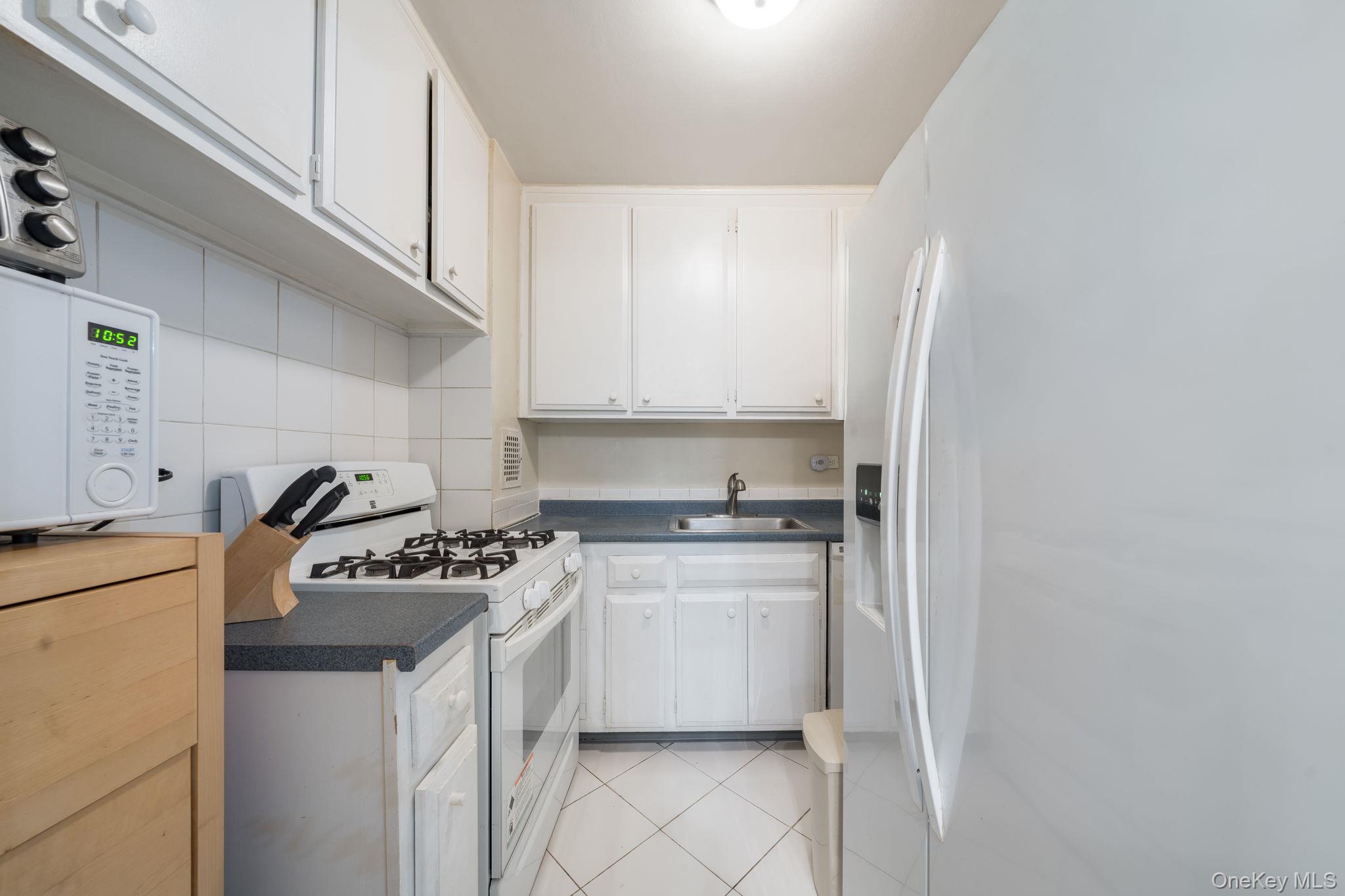 85-15 Main Street, Unit 3E Queens, NY 11435 - Photo 2 of 16 a kitchen with stainless steel appliances granite countertop a stove a sink and a refrigerator