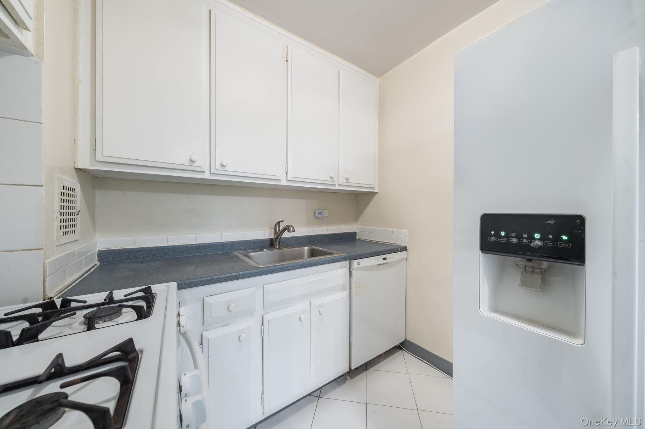 85-15 Main Street, Unit 3E Queens, NY 11435 - Photo 3 of 16 a kitchen with granite countertop a sink and cabinets