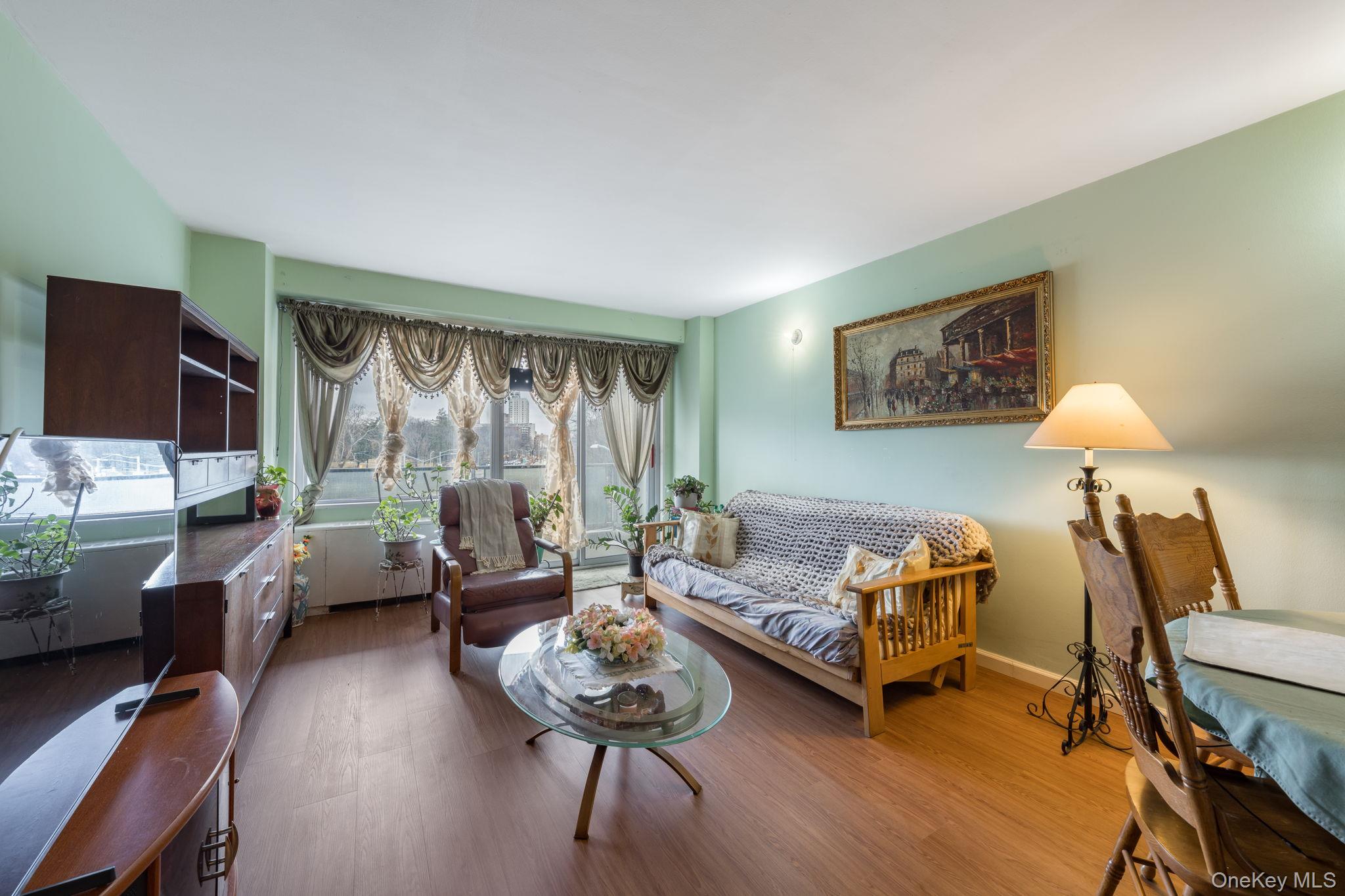 85-15 Main Street, Unit 3E Queens, NY 11435 - Photo 6 of 16 a living room with furniture and a large window