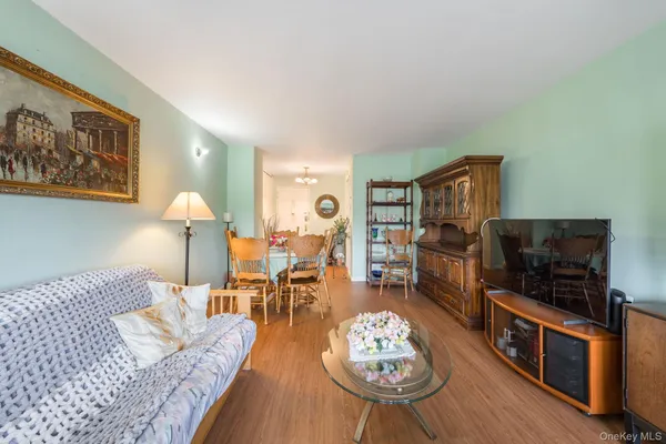 a living room with furniture kitchen view and a flat screen tv