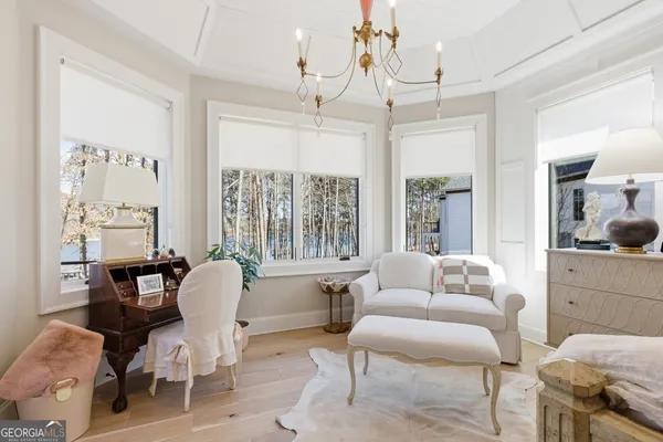 a living room with furniture a chandelier and a flat screen tv