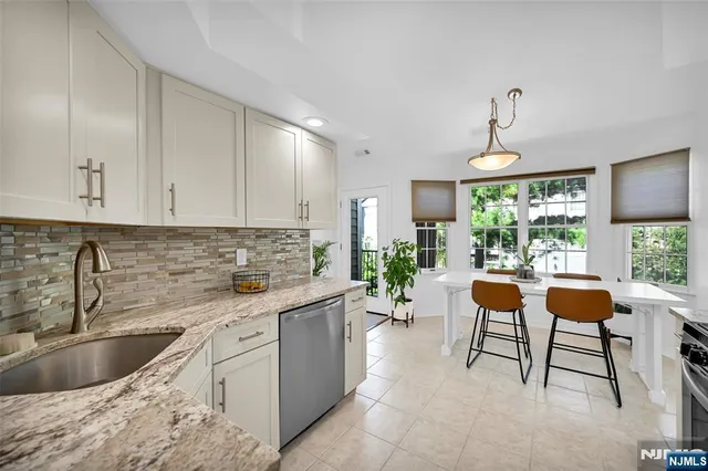 a kitchen with a sink and chairs