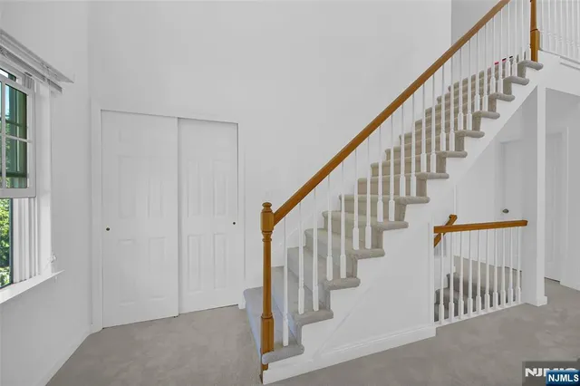 a view of staircase with railing and white walls