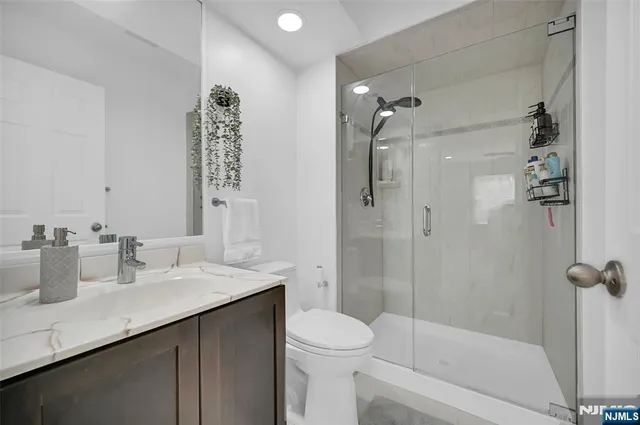 a bathroom with a sink a toilet and shower