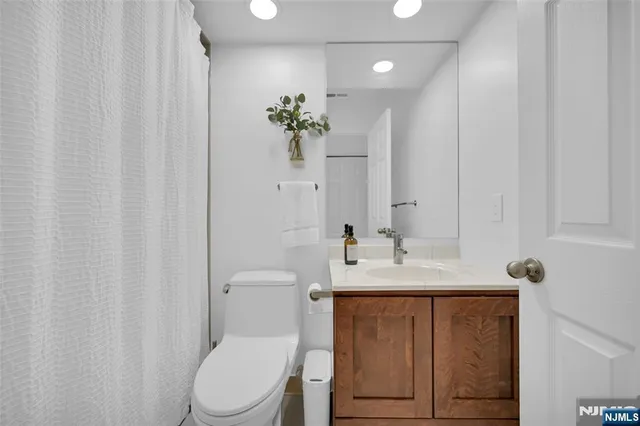 a bathroom with a toilet a sink and a mirror