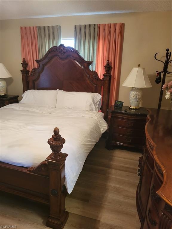 843 Marblehead Drive, Unit I3 Naples, FL 34104 - Photo 24 of 35 a bedroom with a bed and a chandelier