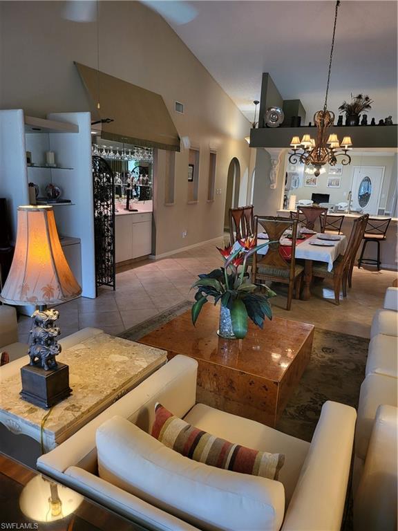 843 Marblehead Drive, Unit I3 Naples, FL 34104 - Photo 29 of 35 a living room with furniture a chandelier and a flat screen tv