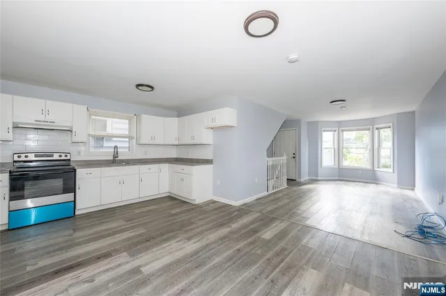 a view of kitchen with granite countertop cabinets and wooden floor