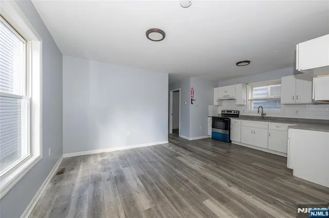 a kitchen with granite countertop a sink cabinets and stainless steel appliances