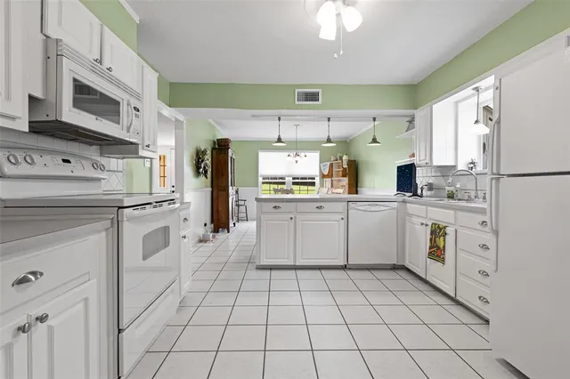 a kitchen with white cabinets stainless steel appliances and sink
