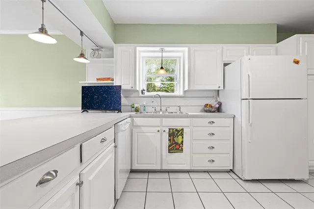 a kitchen with cabinets appliances a sink and a window