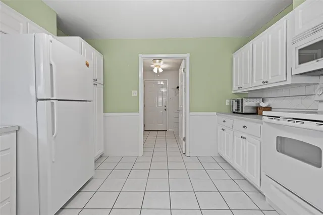 a kitchen with white cabinets and white appliances