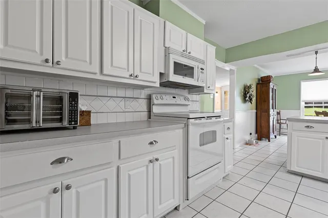 a kitchen with white cabinets and white appliances
