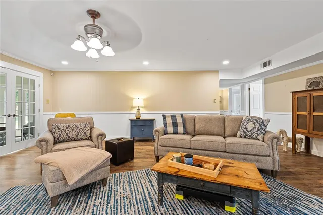 a living room with furniture a rug and a chandelier