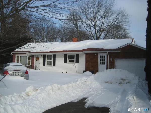 a front view of a house with a yard covered in snow