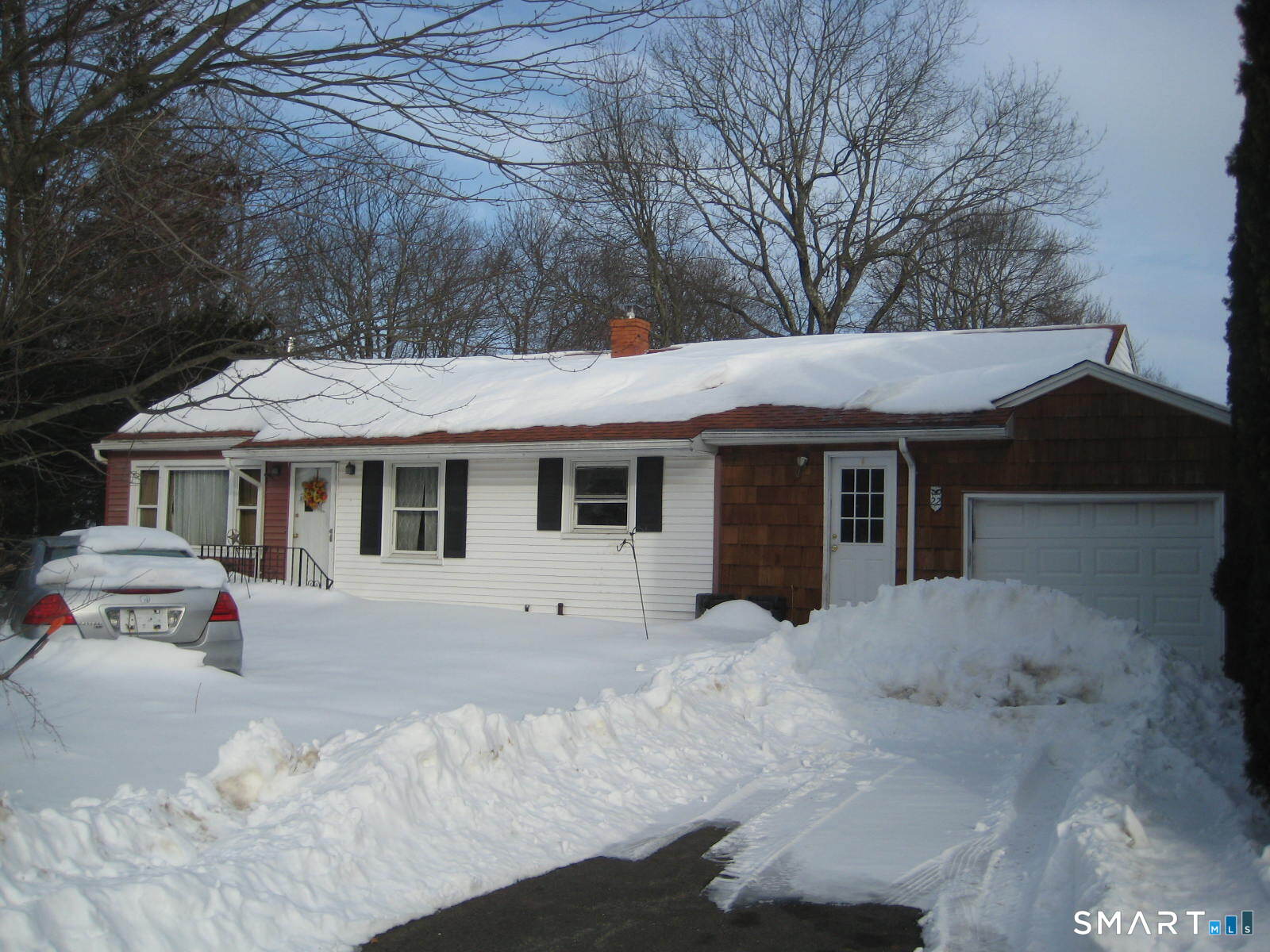 a front view of a house with a yard covered in snow