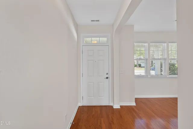a view of a room with wooden floor chandelier and entryway