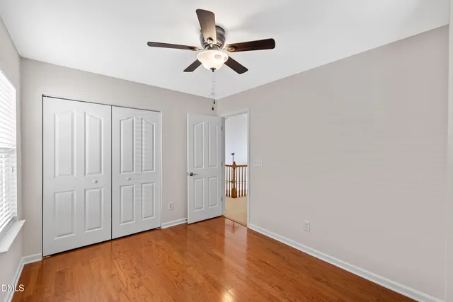 a view of a big room with wooden floor and windows