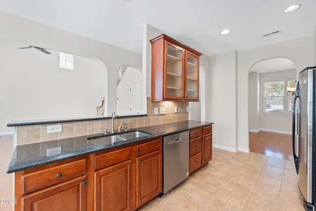 a large kitchen with stainless steel appliances granite countertop a stove a sink dishwasher and a refrigerator