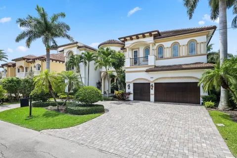 a living room with a white couches a fireplace and a potted plant