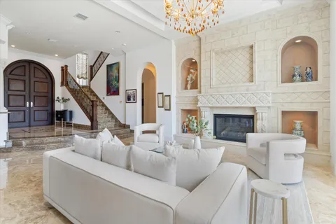 a living room with furniture a chandelier and a fireplace