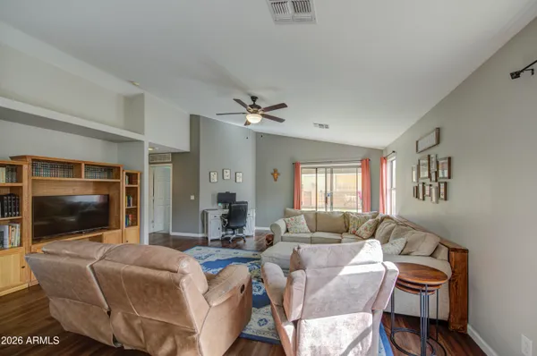 a living room with furniture a flat screen tv and a window