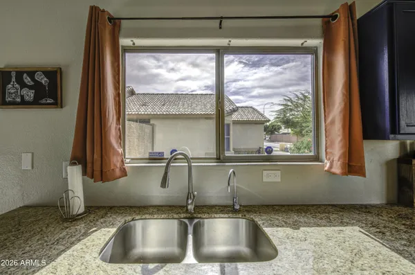 a kitchen with stainless steel appliances granite countertop sink stove refrigerator and cabinets