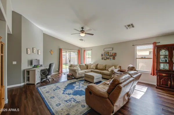 a living room with furniture two window and wooden floor