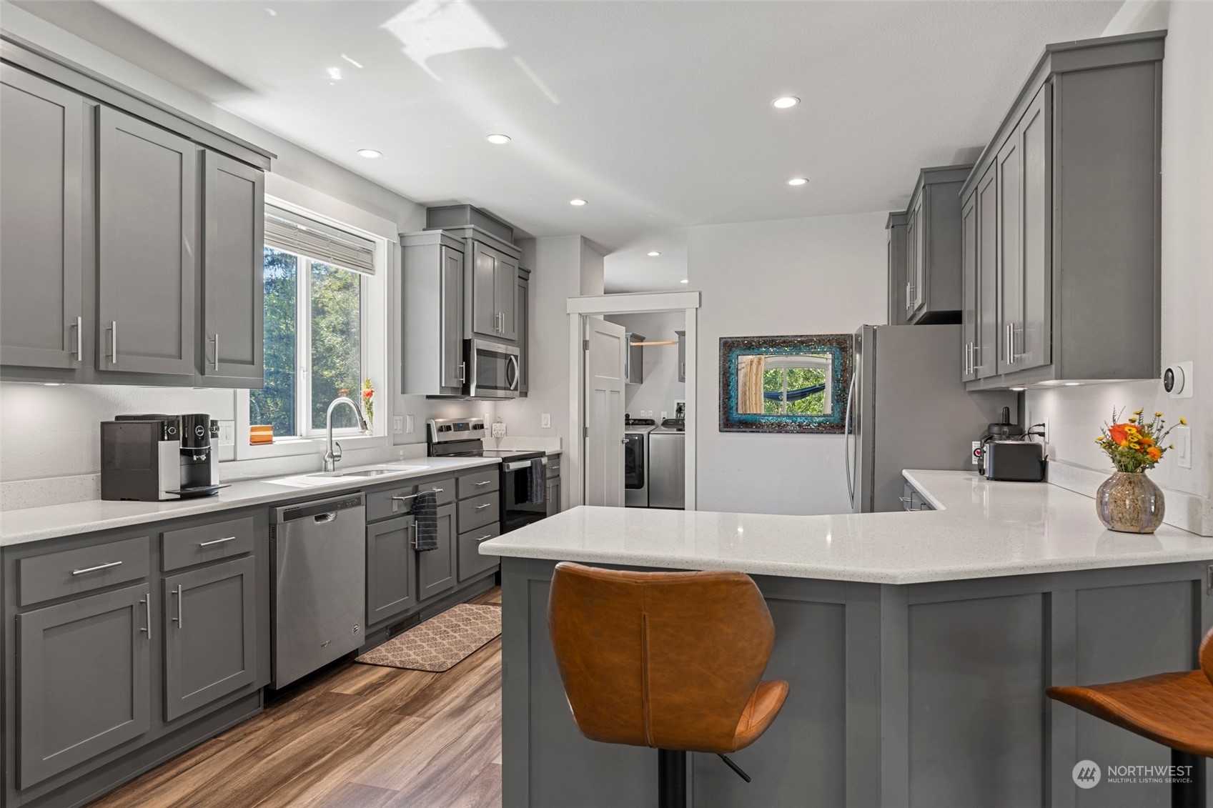 6303 Kirkhill Road Clinton, WA 98236 - Photo 12 of 40 a large kitchen with kitchen island granite countertop a sink a stove a dining table and chairs