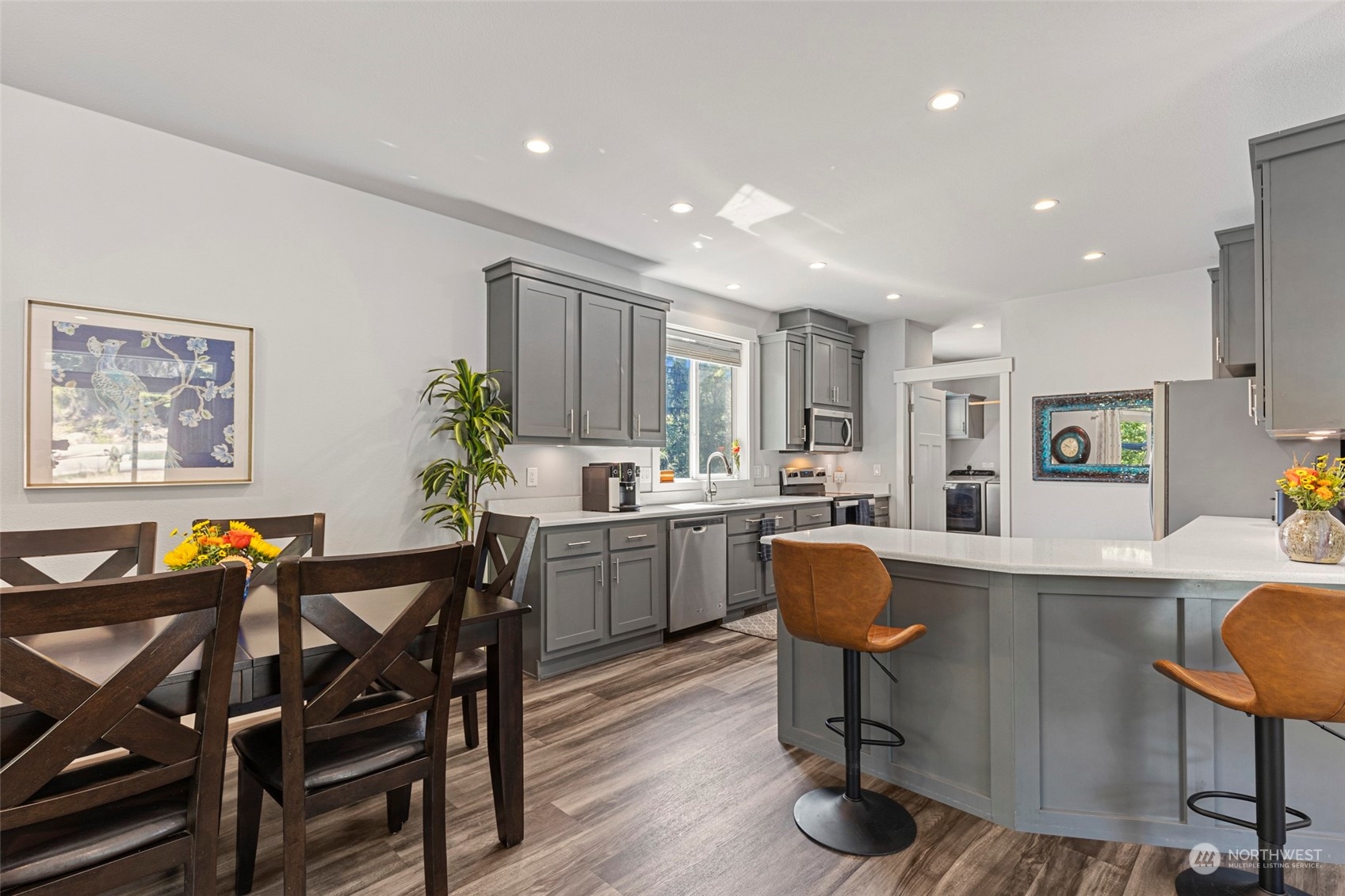 6303 Kirkhill Road Clinton, WA 98236 - Photo 18 of 40 a kitchen with stainless steel appliances a dining table chairs and a refrigerator