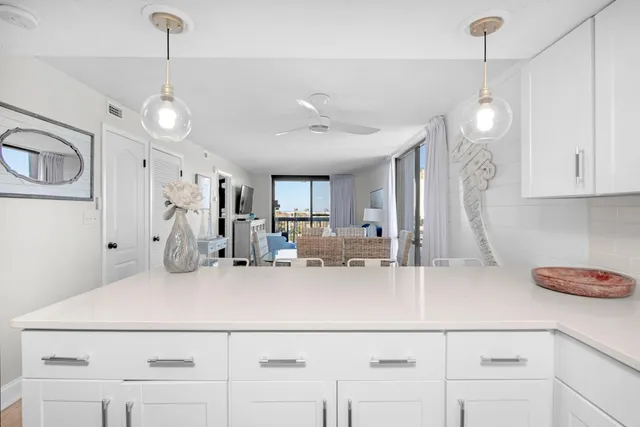 a kitchen with kitchen island white cabinets and refrigerator