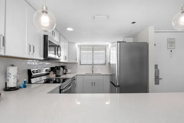 a kitchen with stainless steel appliances a refrigerator a sink a stove a microwave and cabinets