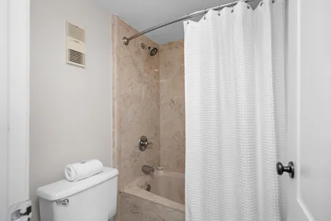 a bathroom with a shower curtain and a toilet
