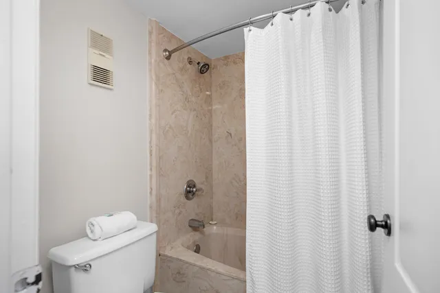 a bathroom with a shower curtain and a toilet